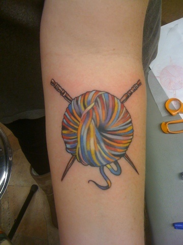 Colorful Yarn With Knitting Needles Tattoo On Forearm