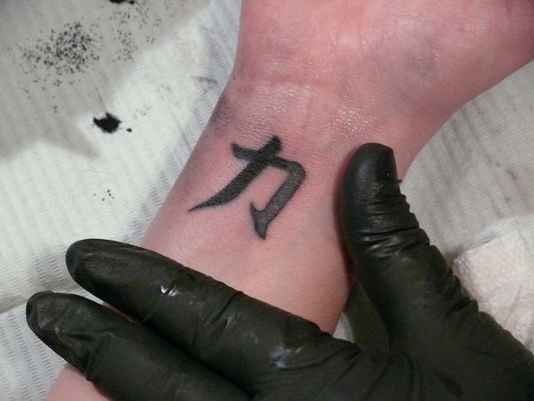 Dark Black Chinese Strength Symbol Tattoo On Wrist