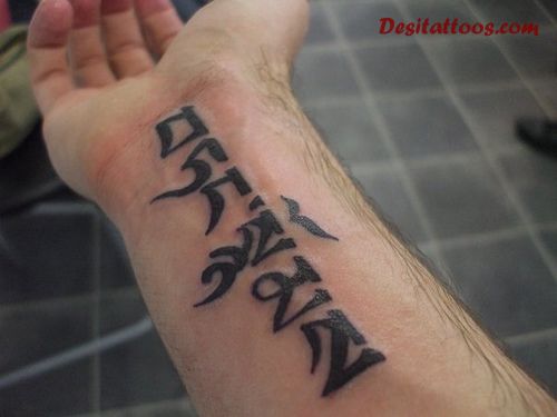 Dark Black Tibetan Script Tattoo On Forearm