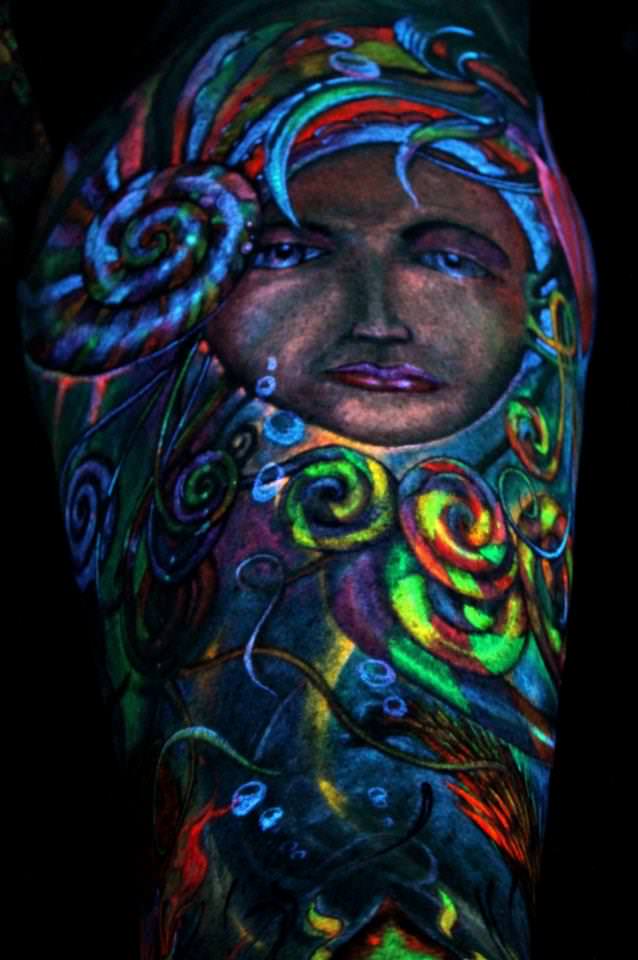 Female Face Peeks From Nautilus Shell UV Tattoo