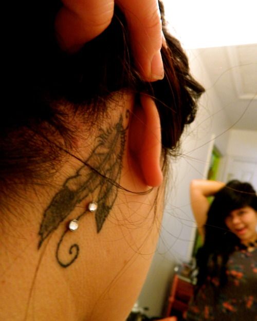 Grey Feather Tattoos And Dermal Anchor Piercings Behind The Ear