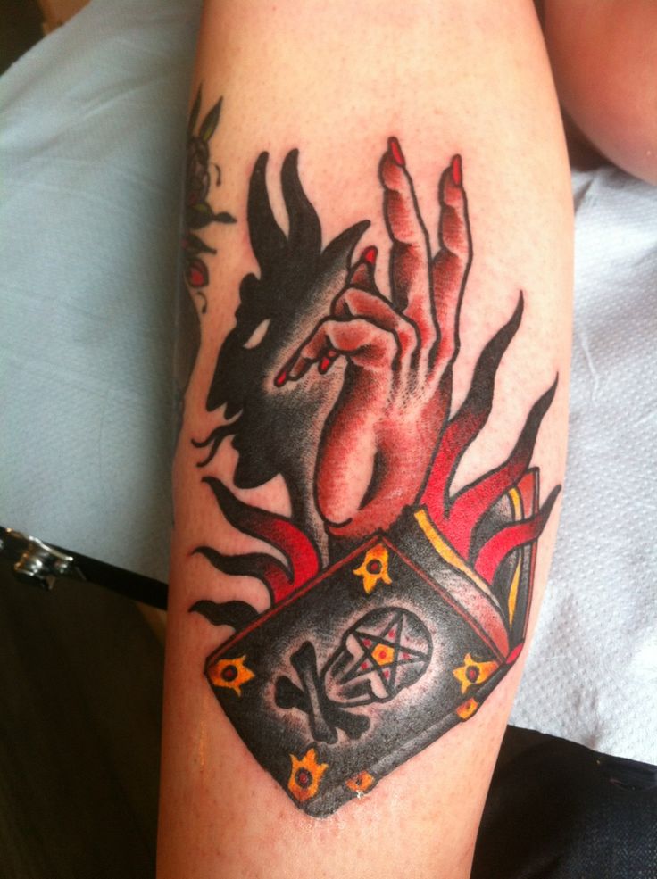 Hand Making Satan Shadow Tattoo On Arm