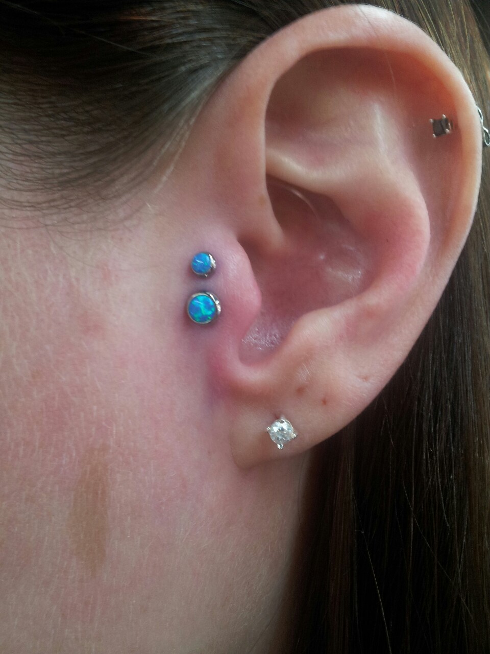 Left Ear Lobe And Double Tragus Piercing With Blue Opal studs