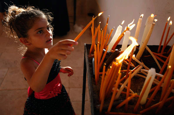 Little Girl Lightning Candles During The Celebration Of Assumption Of Mary