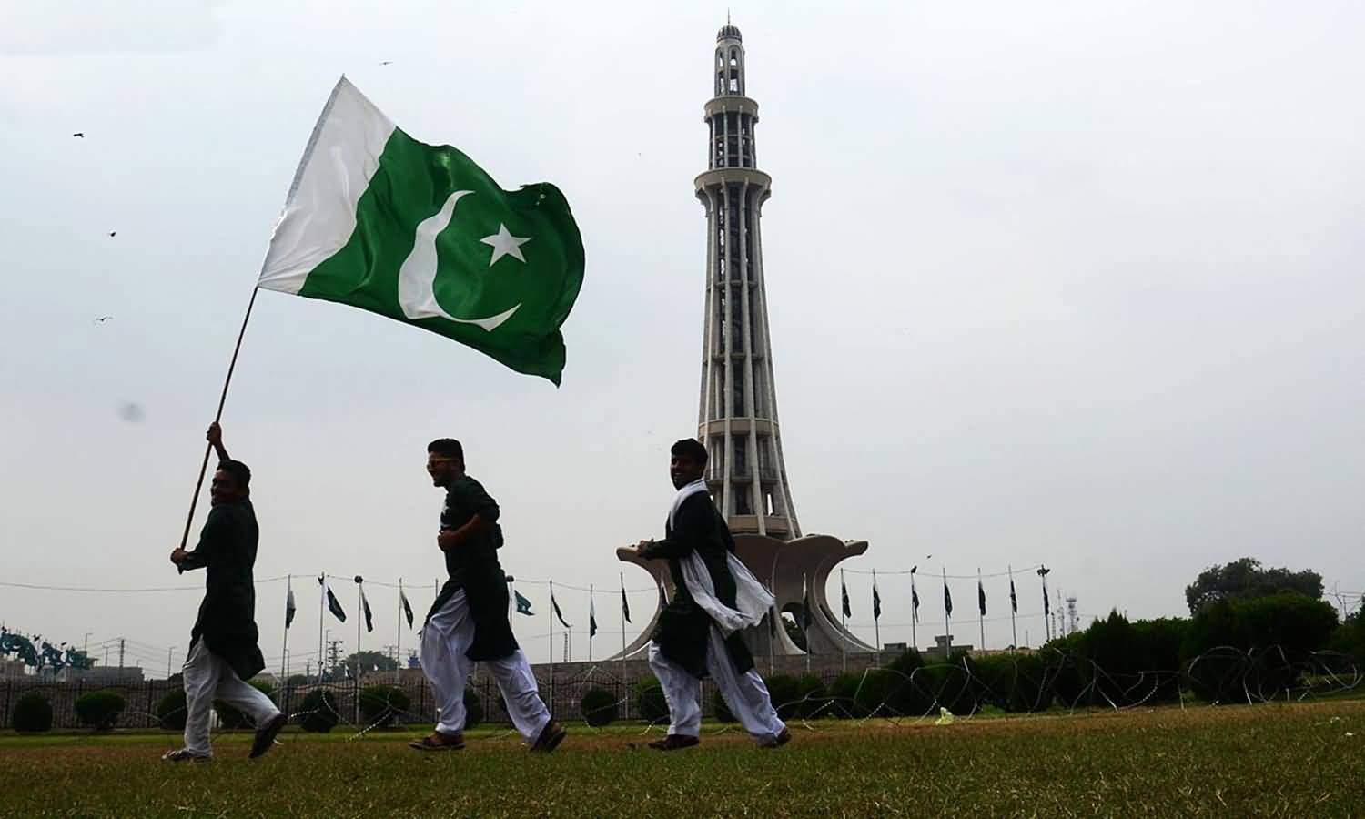 Man Holding Pakistan National Flag At Minar-E-Pakistan On The Occasion Of Independence Day