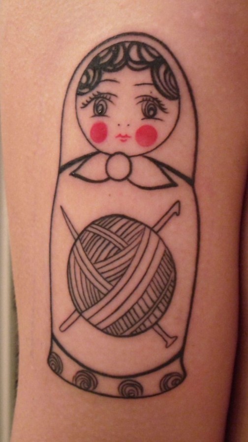 Matryoshka With Red Cheeks And Needles In Yarn Tattoo