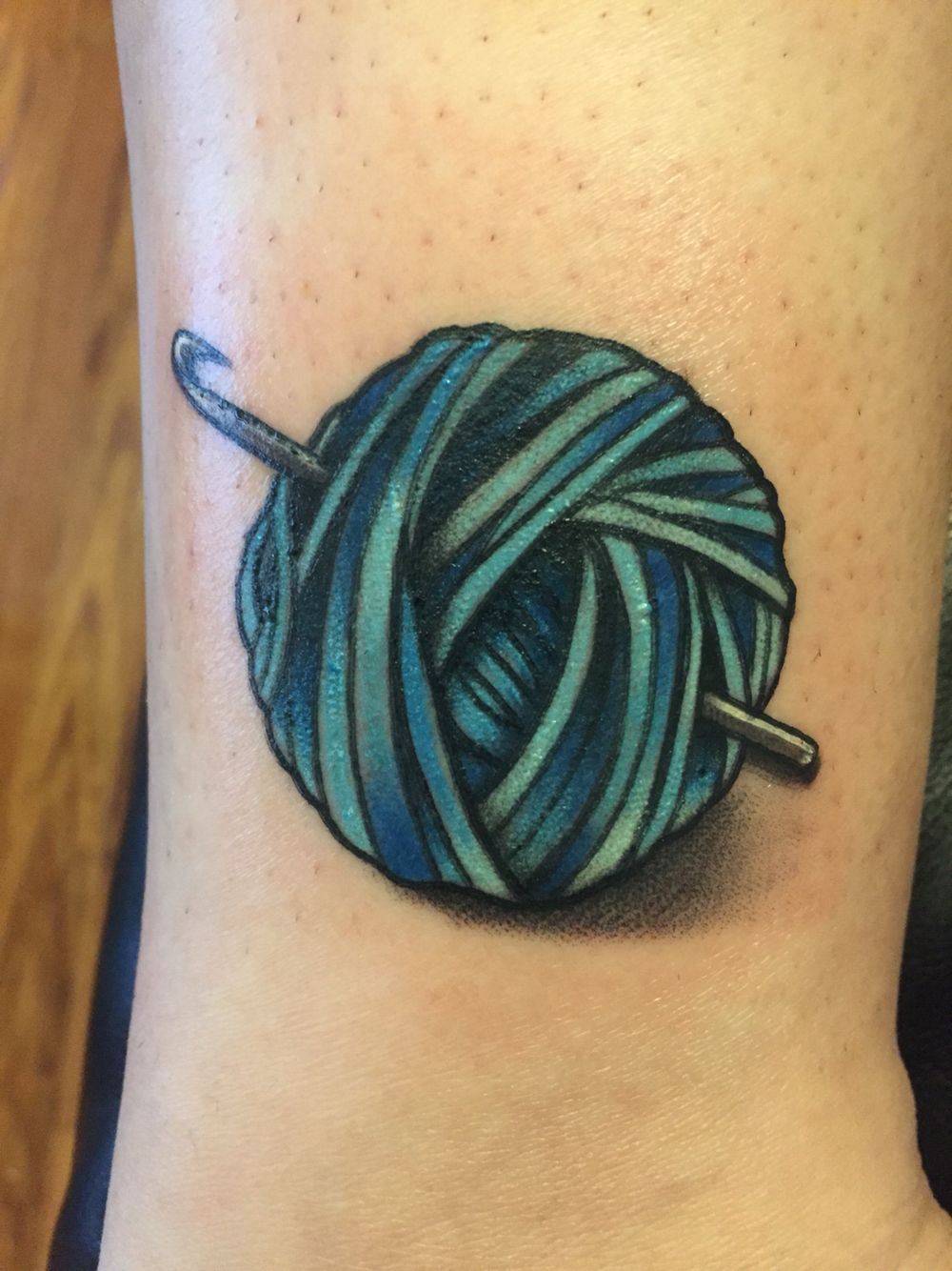 Nice Green Ball Of Yarn With Crochet Hook Tattoo On Wrist