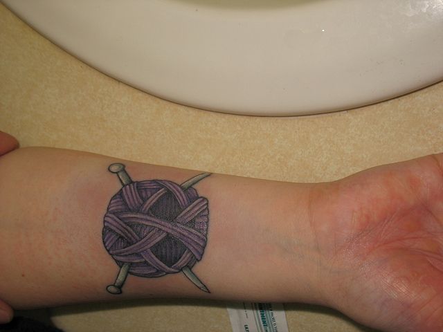 Nice Purple Yarn Tattoo On Forearm