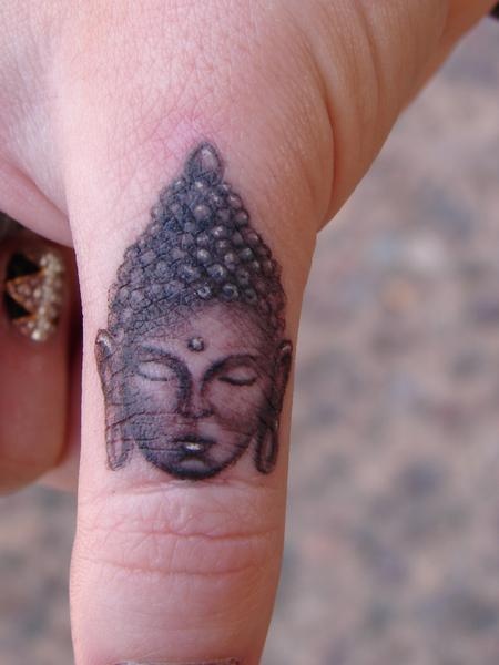 Small Buddha Face Spiritual Tattoo On Thumb