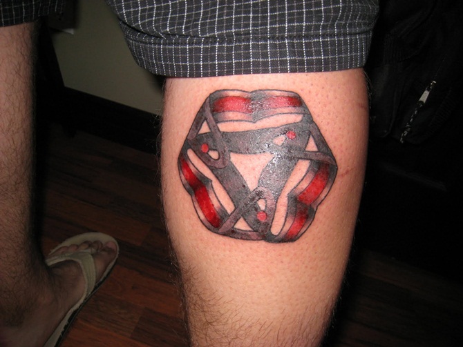 Small Escher Symbol Tattoo On Back Leg
