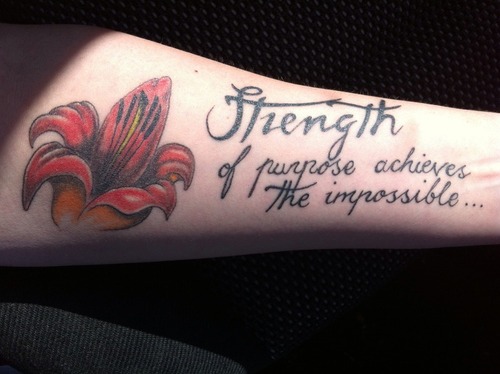 Strength Quote With Flower Tattoo On Forearm