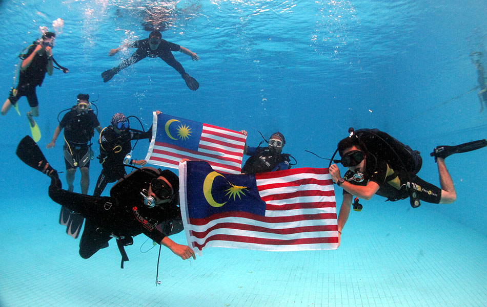 Divers With Malaysian Flag Under Water During Malaysia Day