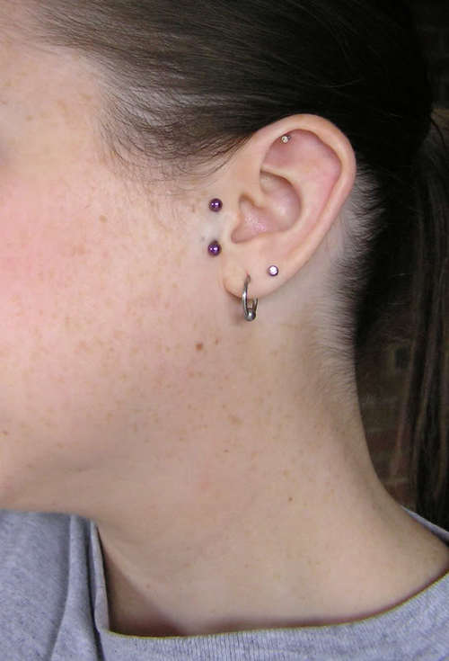 Left Ear Lobe And Surface Tragus Piercing With Purple Barbell
