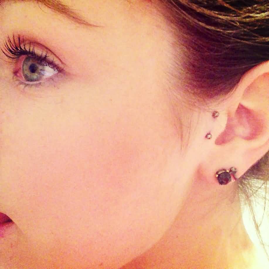 Left Ear Lobe And Surface Tragus Piercing With Silver Barbell
