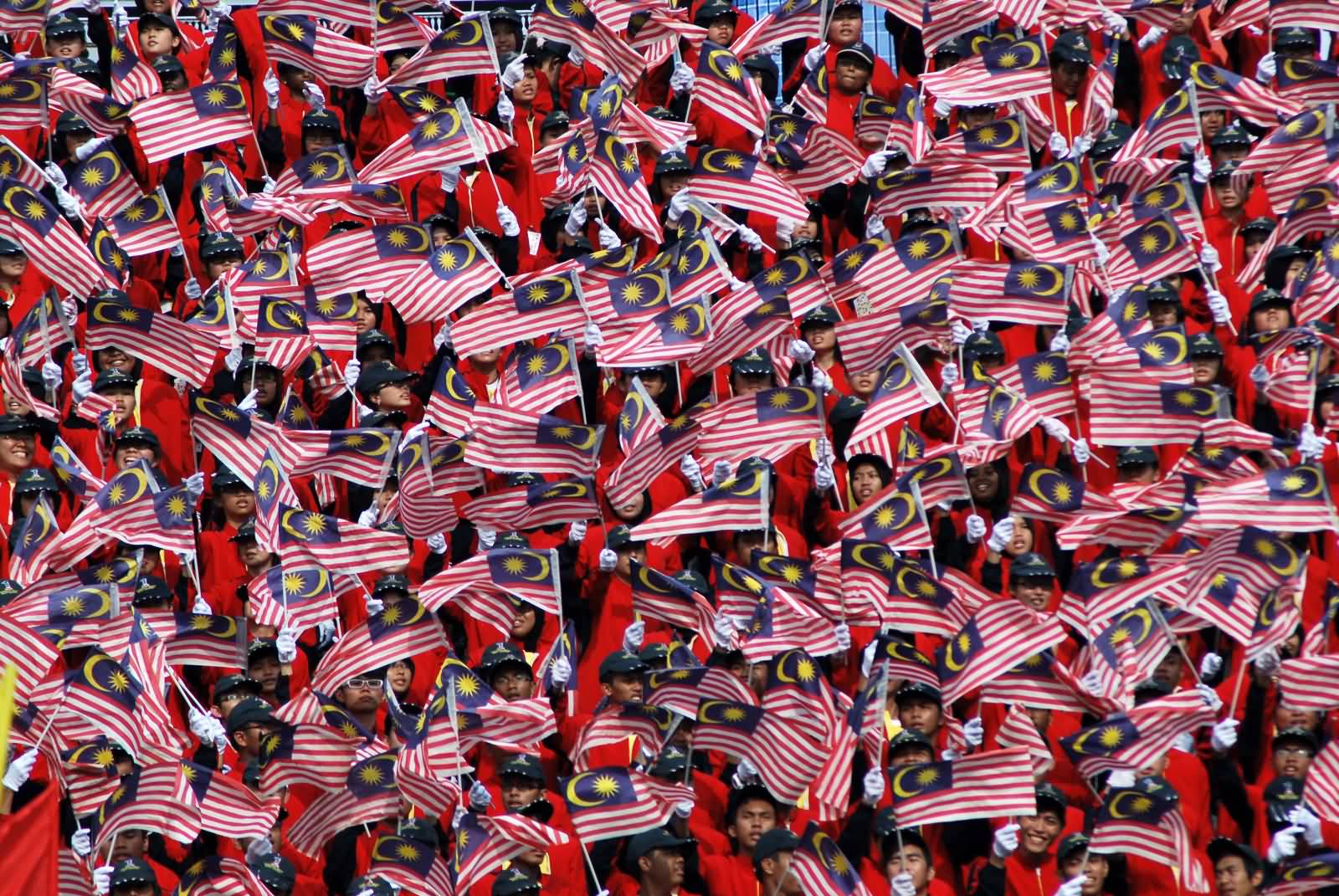 Malaysians Waves Their National Flags During Malaysia Day Celebration