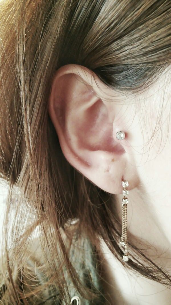 Tragus Piercing With Opal Stud On Girl Right Ear