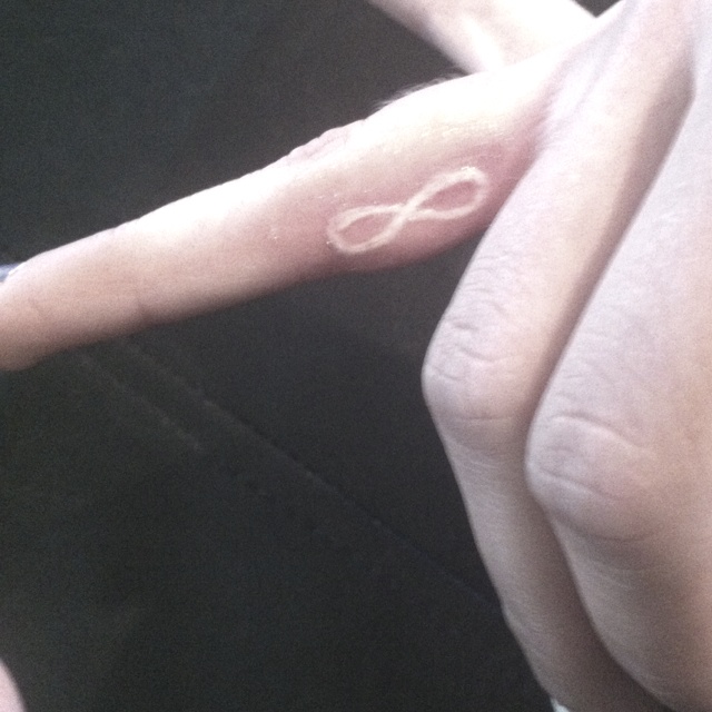 White Ink Infinity Symbol Tattoo On Finger