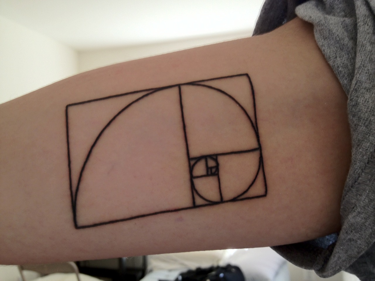 Black Fibonacci Spiral Tattoo On Biceps