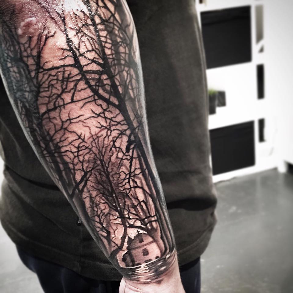 Black and grey dry trees and church tattoo on arm