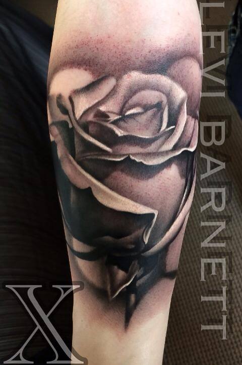 Black and grey rose tattoo on arm by Levi Barnett