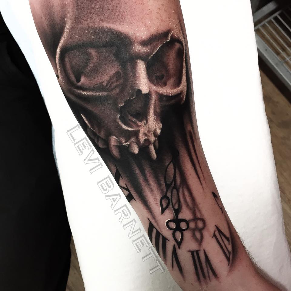 Broken skull and clock tattoo on arm by Levi Barnett