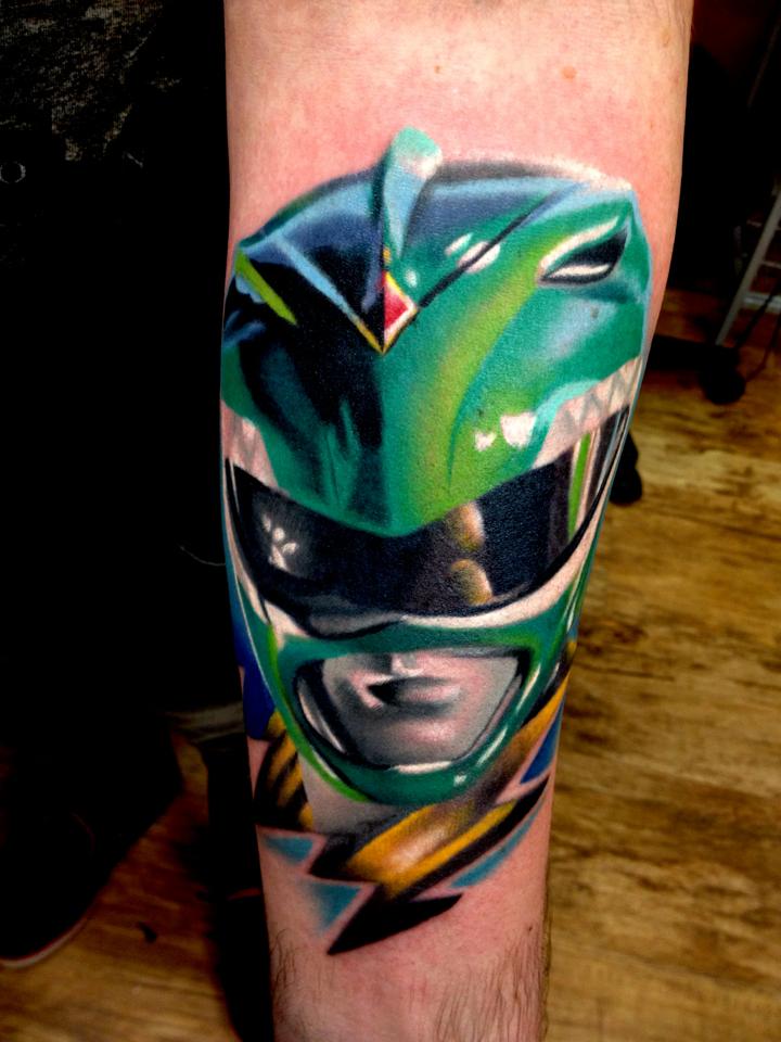 Green mask tattoo on arm by Levi Barnett