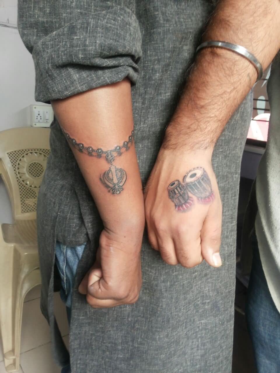 Grey Ink Khanda With Chain And Tabla Tattoos On Hands
