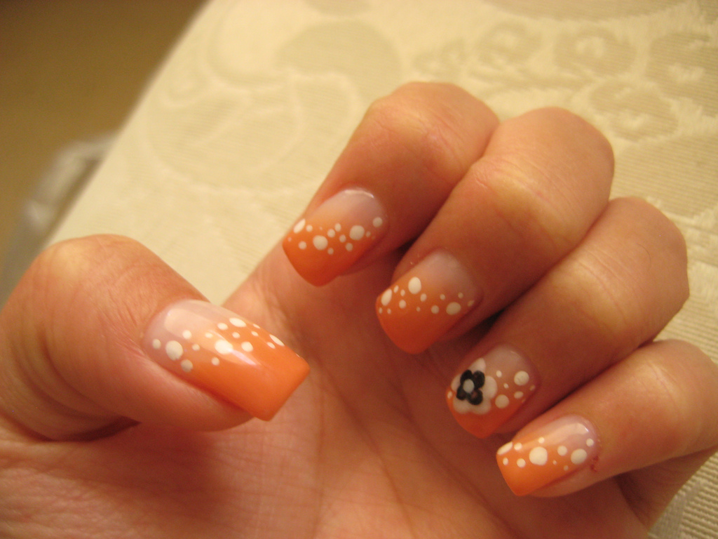 Orange Nails With White Dots And Flower Design Nail Art