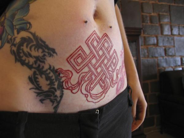 Red Color Endless Knot Tattoo On Stomach