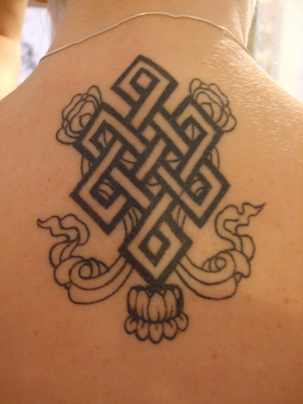 Spiritual Endless Knot With Flower Tattoo On Upper Back