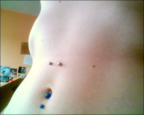 Surface Navel Piercings With Silver And Blue Barbells