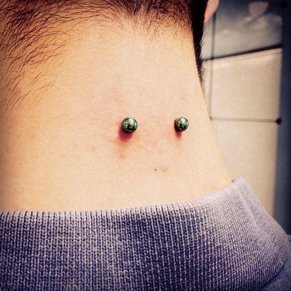 Surface Neck Piercing With Green Barbell
