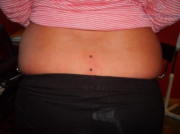 Vertical Lower Back Piercing With Silver Barbell