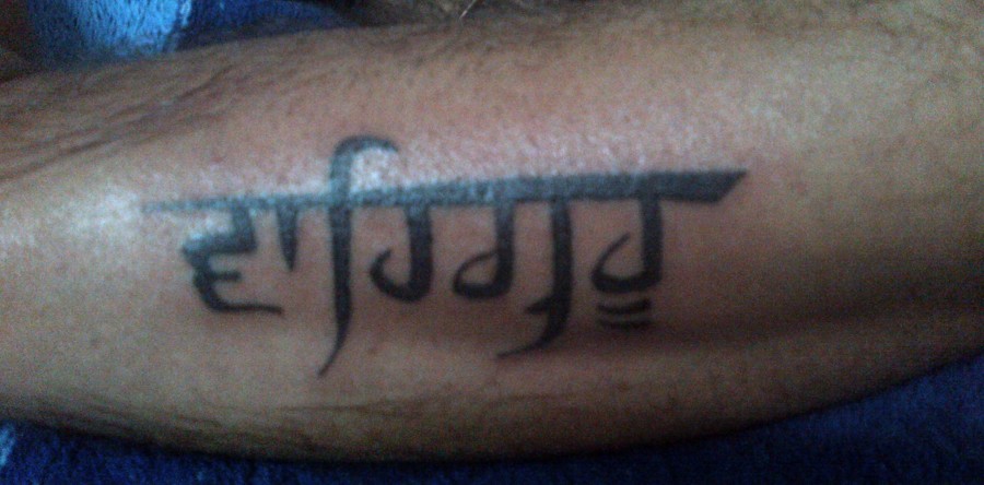 Waheguru In Punjabi Font Tattoo On Arm Sleeve