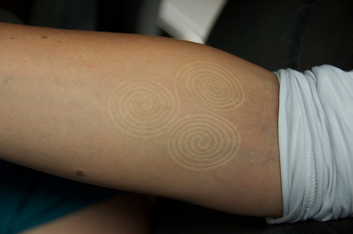 White Ink Spiral Tattoo On Forearm