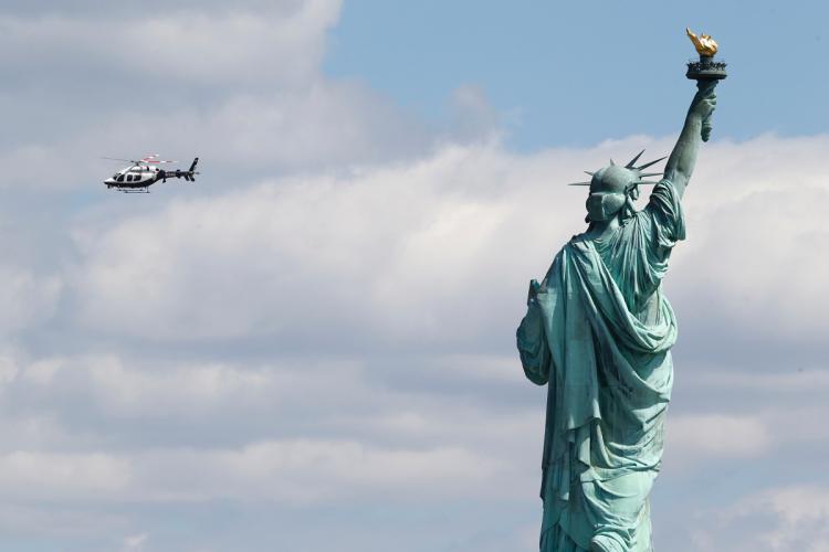 A New York Police Helicopter Circles Over Statue Of Liberty