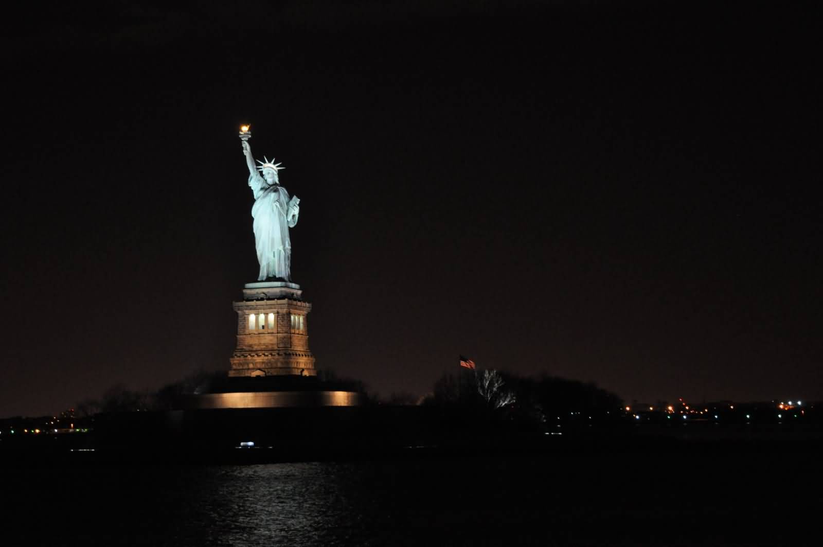 Across The River View Of Statue Of Liberty At Night