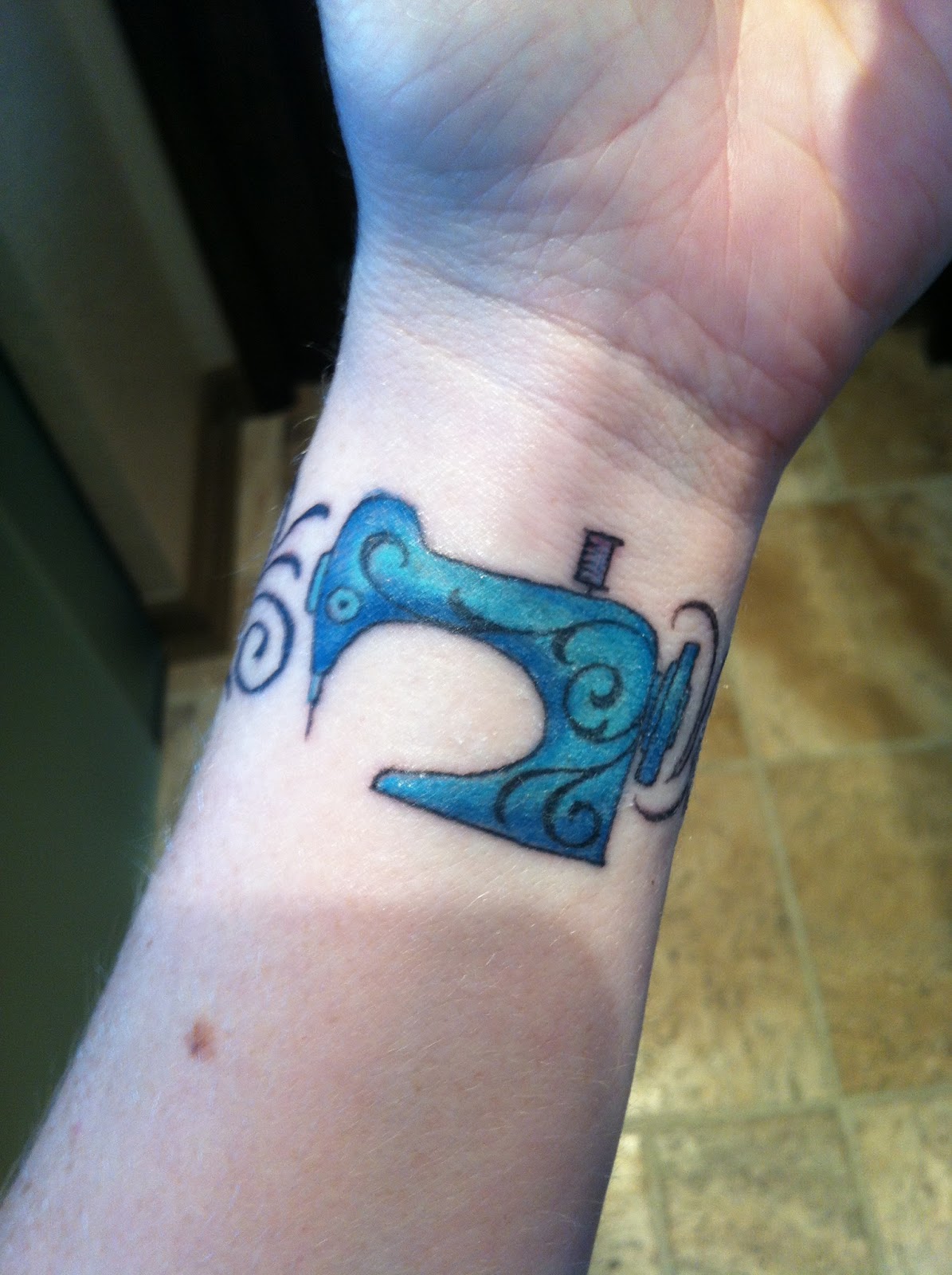 Blue Ink Sewing Machine Tattoo On Wrist