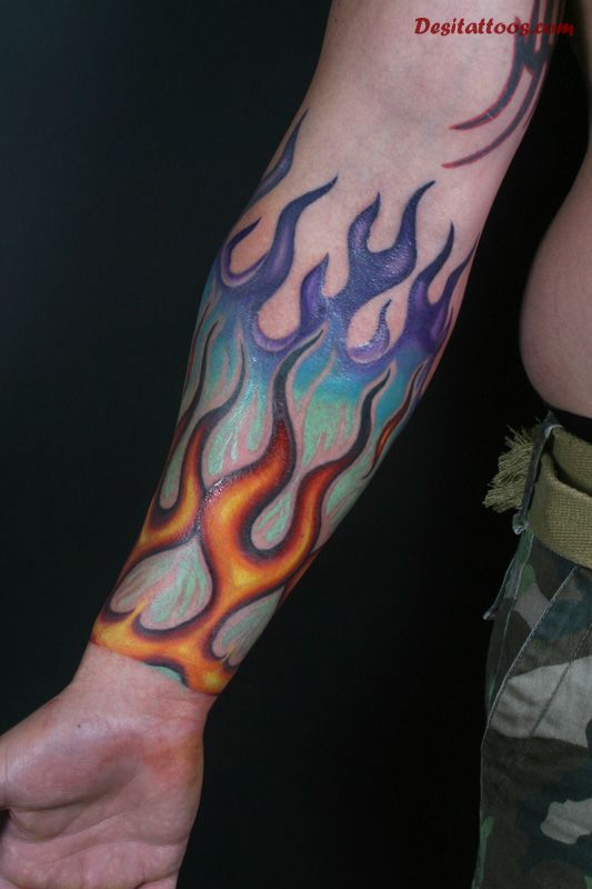 Colorful Tribal Fire Flame Tattoo On Forearm