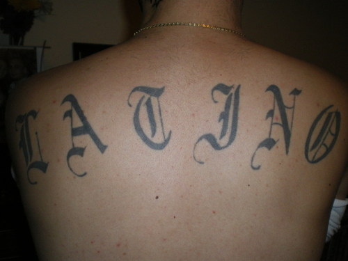 Latino Word Tattoo On Upper Back