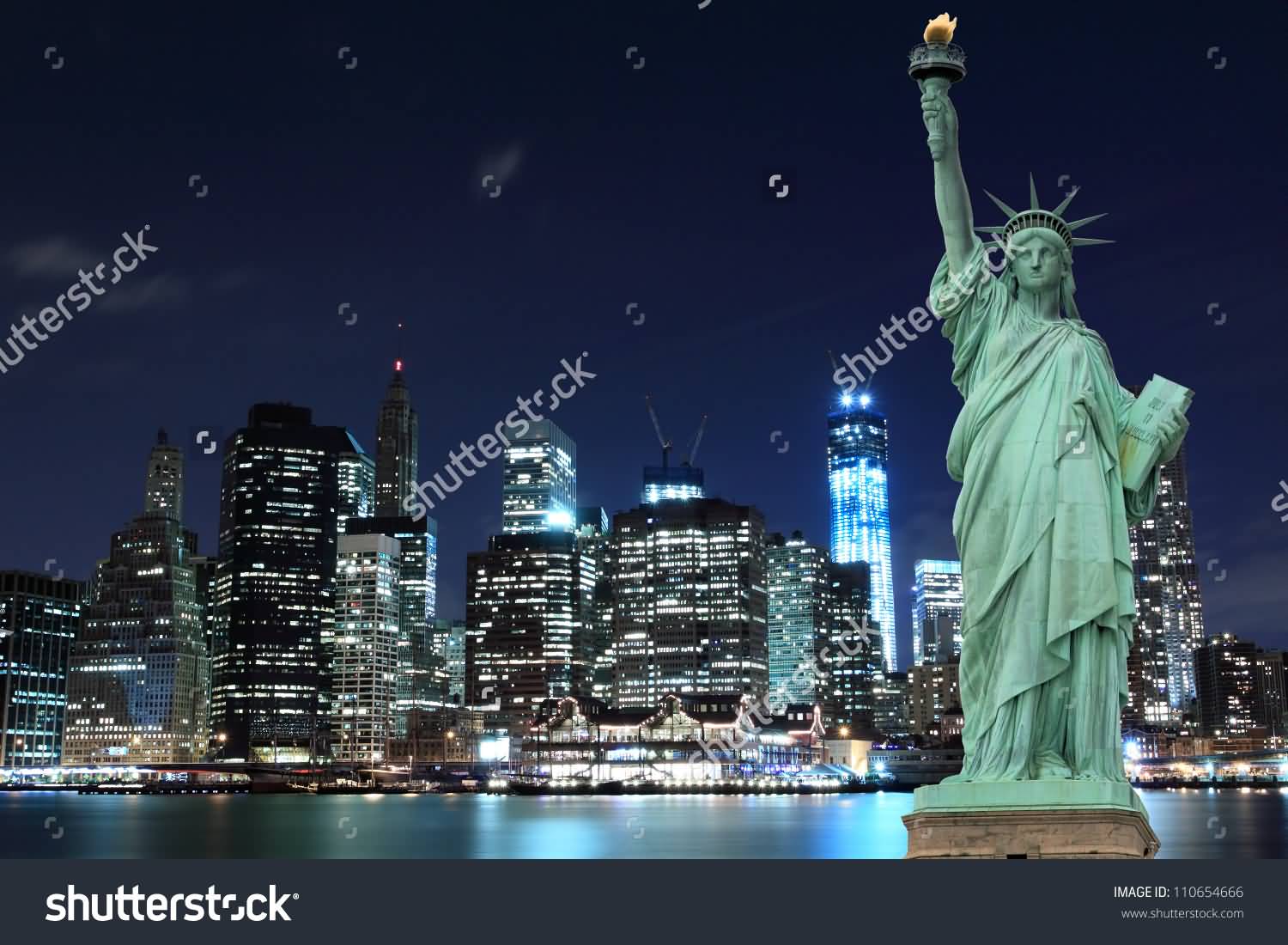Manhattan Skyline And Statue Of Liberty Illuminated At Night