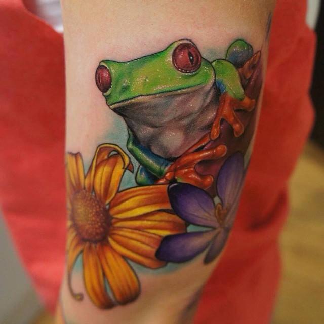 Nice Frog With Flowers Tattoo On Biceps