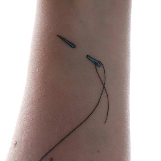 Ripped Skin Sewing Needle Tattoo On Arm