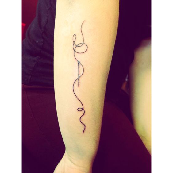Sewing Needle And Thread Tattoo On Forearm
