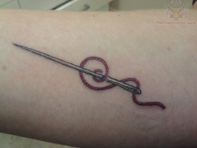 Sewing Needle With Thread Tattoo On Forearm