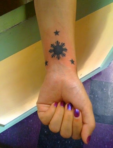 Small Black Filipino Sun With Stars Tattoo On Girl Wrist