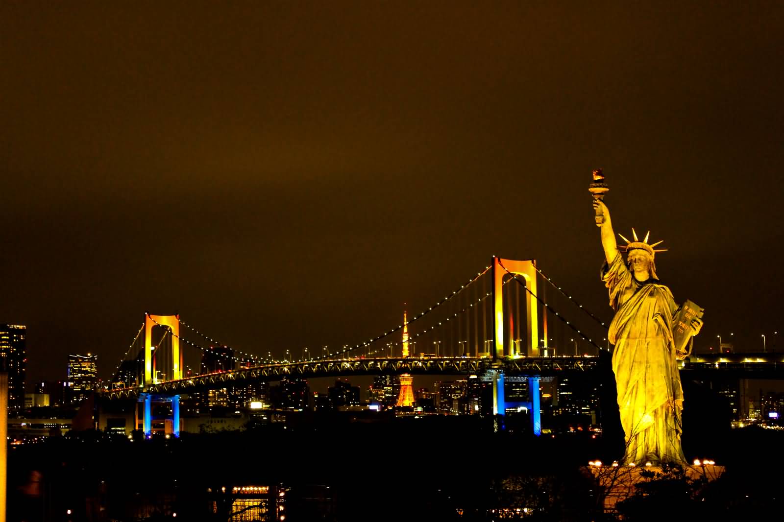 Statue Of Liberty And Harbor Bridge Lit Up At Night