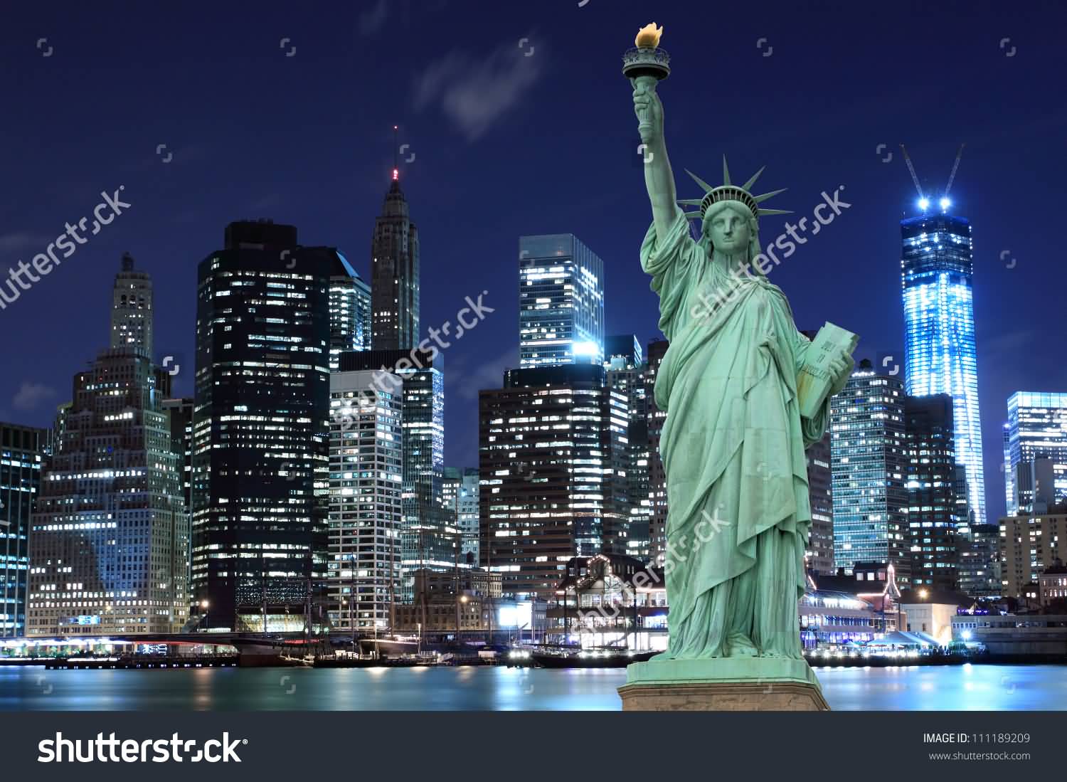 Statue Of Liberty And Manhattan Skyline At Night