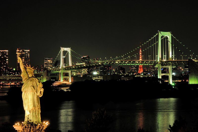 Statue Of Liberty And Rainbow Bridge During Night
