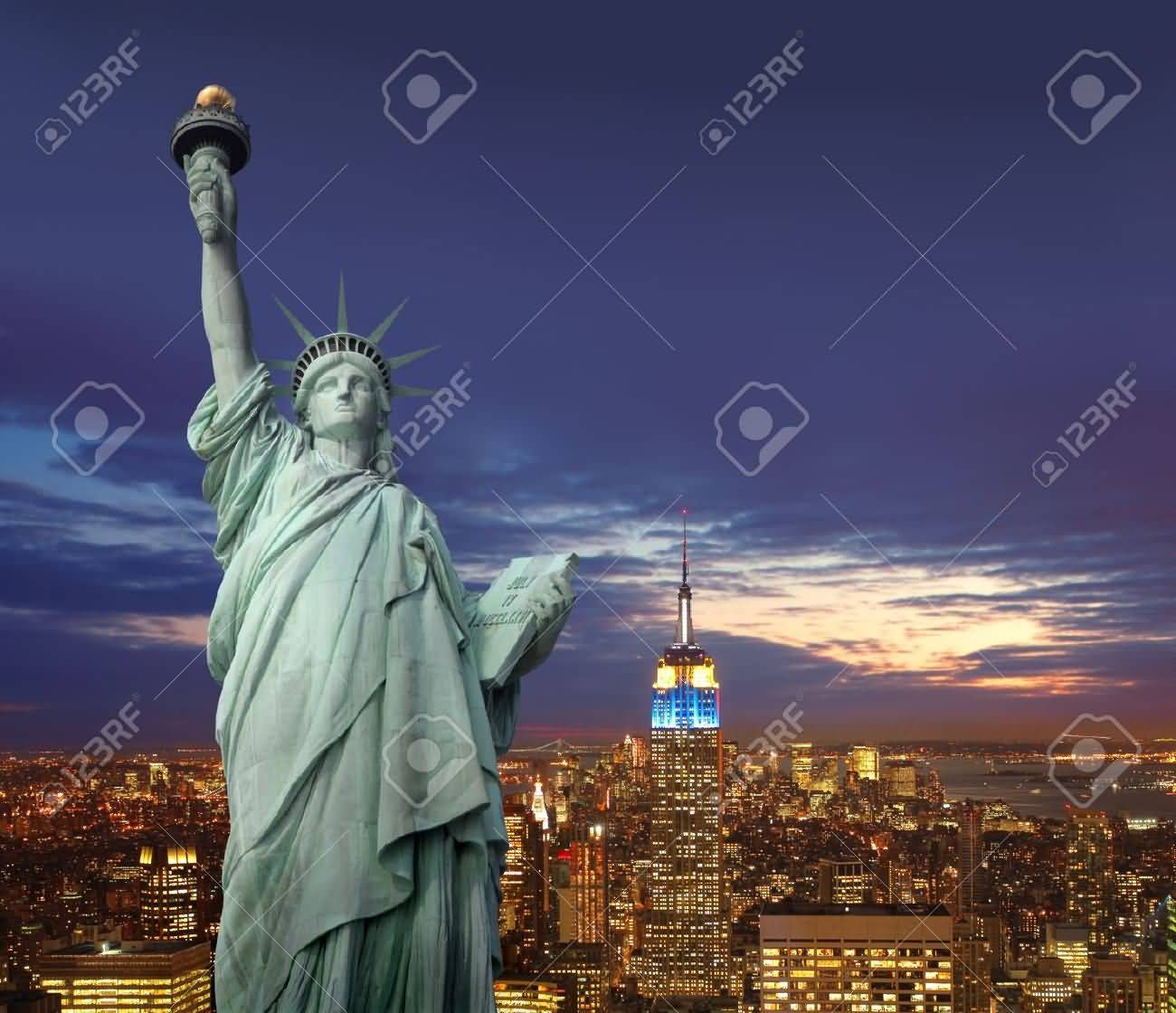Statue Of Liberty With Night View Of New York City In The Background